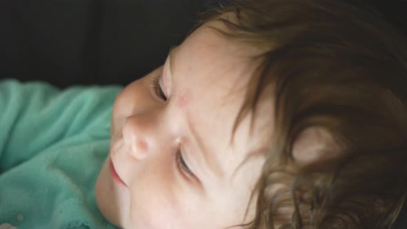 Slow Motion of Baby with Beautiful Eyes Looking at Moving Mobile alt