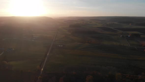 Long Straight Road In Vast Green Landscape at Sunset Aerial