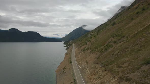 Beautiful View of Scenic Road Alongside Peaceful Lake alt