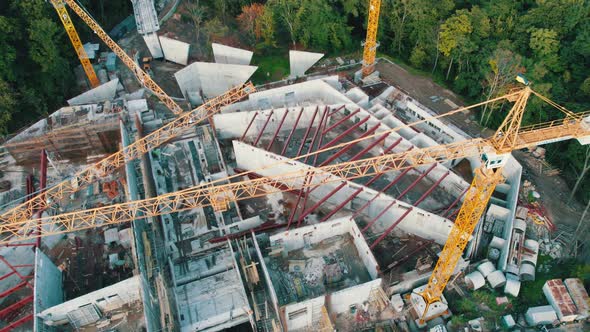 Aerial View Construction of a New Building with High Tower Cranes in Green Area alt