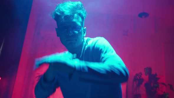 Stylish Dancer Moves to Music in a Smoky Room with Neon Lighting alt
