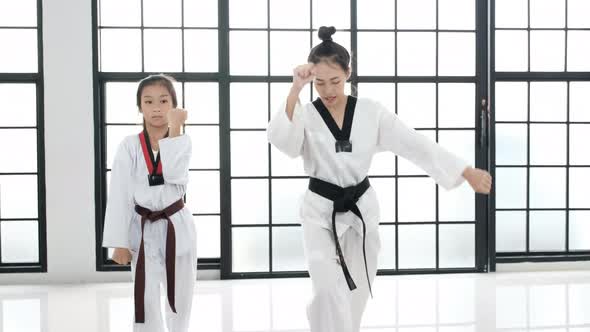 Young teacher of taekwondo and her student is acting of basic posture with white background