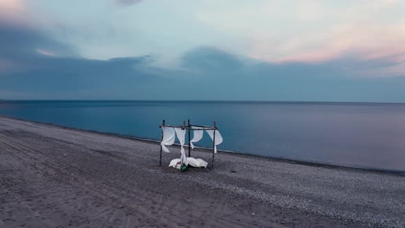 Four poster bed by the sea on the beach alt