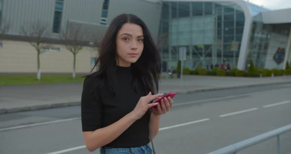 The Girl Is Smiling and Corresponds in the Phone When Standing Near the Airport alt