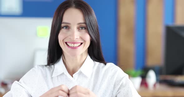 Beautiful Woman Shows a Sign in the Shape of Heart on Face Closeup alt