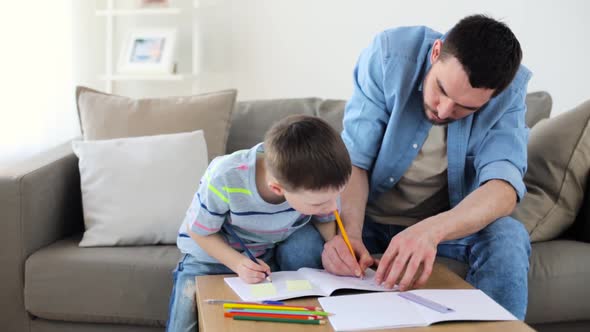 Father and Little Son with Crayons Drawing at Home alt