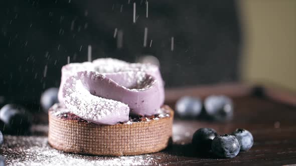 Pastry Chef Is Sprinkles a Cake with Powdered Sugar in Slow Motion, Close-up.