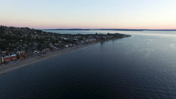 Wide establishing aerial shot of the Alki Beach shoreline in West Seattle. alt