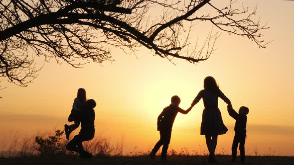 Silhouettes of Family Spending Time Together in the Meadow Near During ...