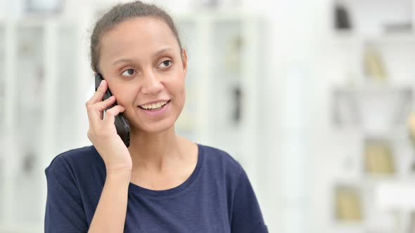 Portrait of Cheerful African Woman Talking on Smartphone alt