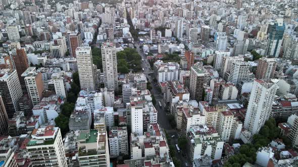 Aerial lowering over Belgrano neoghborhood buildings at sunset with bright sun in horizon, Buenos Ai alt