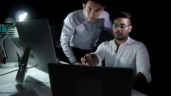 Asian businessman coworkers working night shift discussing project in the office
