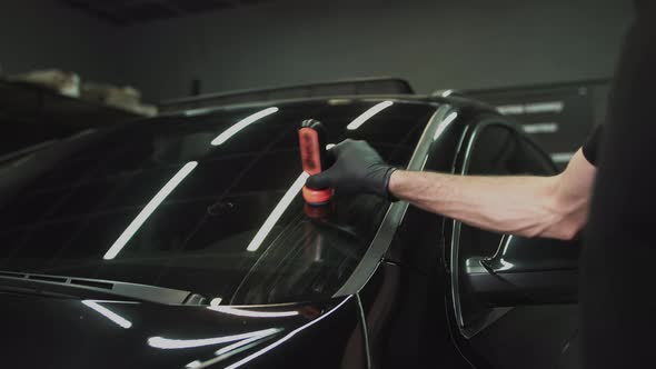 Professional Car Ceramics Worker Applies a Layer of Ceramics Protective Rain alt