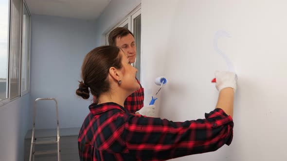 Woman Draws Heart on Wall Repairing House with Husband alt