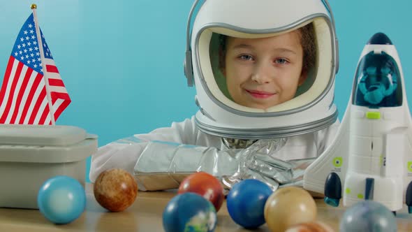 Portrait of a Child Playing at Home in an Astronaut Little Girl 89 Years Old in an Astronaut Costume alt