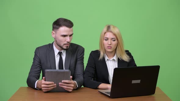 Young Stressed Business Couple Using Laptop Together and Getting Bad News