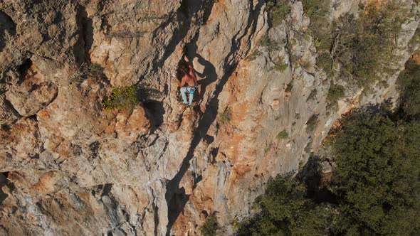 Aerial Drone POV of Strong Muscular Man Climbing Challenging Route on Vertical Crag with Tufa alt