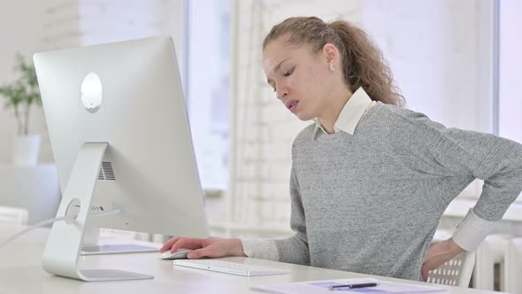 Tired Young Latin Woman Having Back Pain in Modern Office  alt