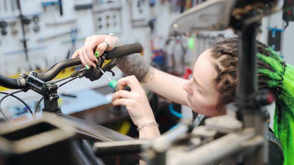 Female Mechanic Fixing Bicycle Handlebar
