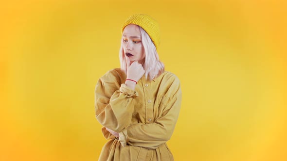 Thinking Woman Looking Up and Around on Yellow. Worried Contemplative Face alt