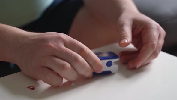 Unrecognised Man's Hands at Home Checking Blood Oxygen Level with Pulse Oximeter alt