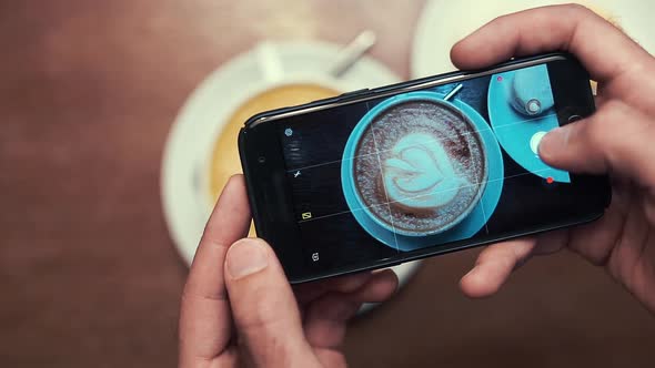 Men's Hands Photographed on A Smartphone Coffee, Latte with A Pattern. alt
