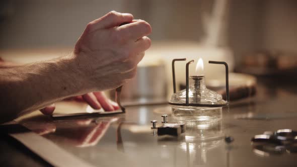 Tailor Heating the Tool and Makes Notches on the Piece of Leather alt