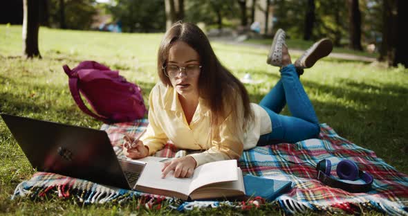 Female Student Studying in Park on Sunset