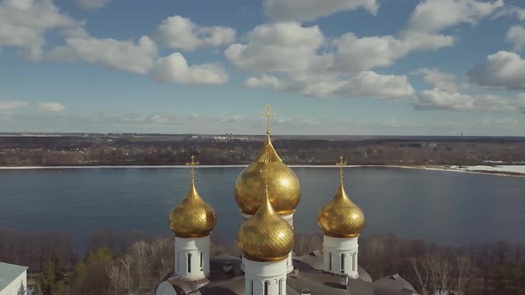 Aerial Footage of Russian Orthodox Church. Drone Flies Around Golden Domes on Background of River