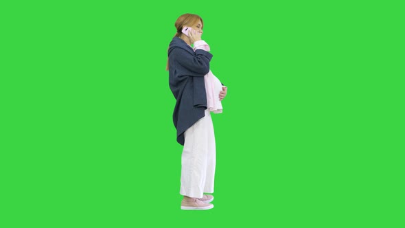 Attractive Pregnant Woman Making Phone Call and Holding Her Tummy on a Green Screen Chroma Key alt