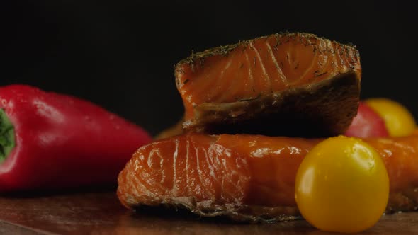 Delicious pieces of smoked salmon on black background