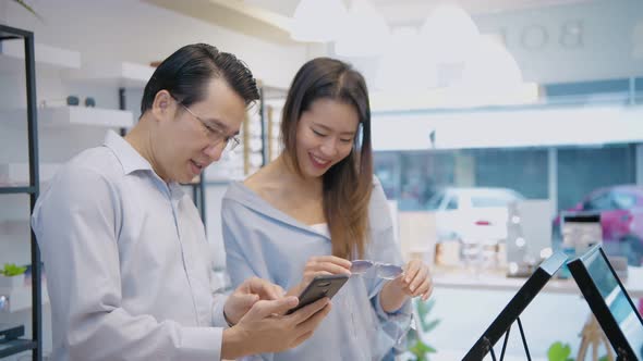 Optical shop concept. A couple shopping for glasses in the store. 4k Resolution. alt