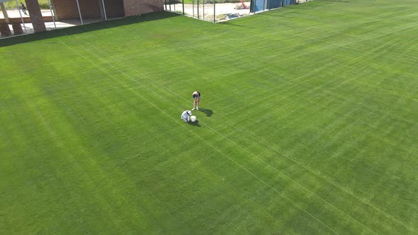 The Girls Weed the Grass on the Football Field By Hand alt