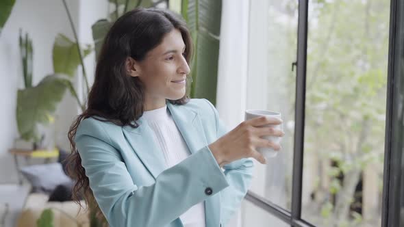 Young Business Woman Satisfied with a Job Well Done Relaxing with Her Morning Coffee or Tea Looking alt