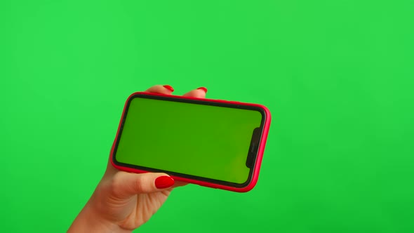 Woman Holds Mobile Phone with Workspace Mock Up Screen in Her Hands on Green Background in alt