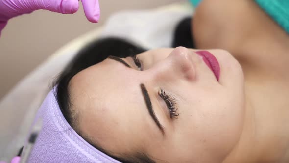 The young beautiful woman in a spa receiving facial treatment injections. alt
