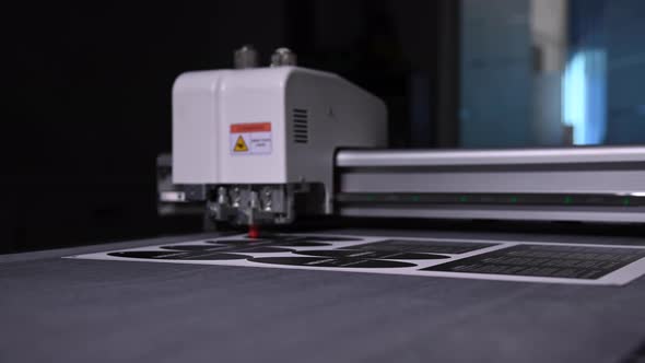 Industrial Plotter Cuts a Template on a Cardboard Packaging for Products alt