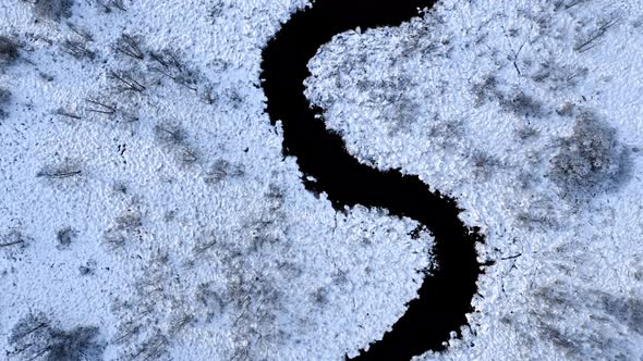 Snowy curvy river in winter. Aerial view of nature alt
