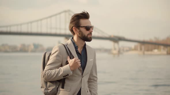Businessman Relaxing And Walking After Work. Businessmen In Suit Stroll On City Beach. alt