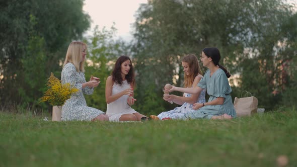 A Group of Young Women in Nature in the Park Hold a Master Class in Clay Modeling alt