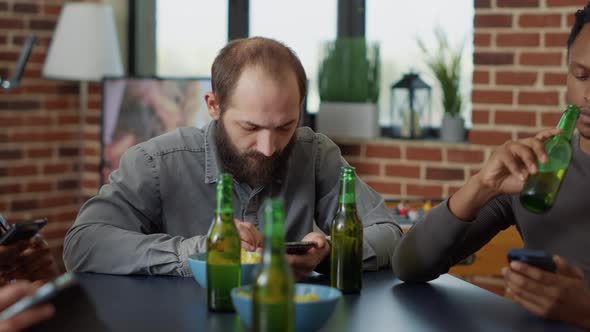 Young Man Hanging Out with Friends and Browsing Internet alt