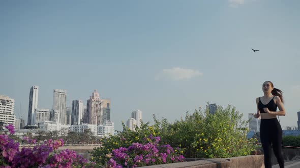 Young woman athlete running resting exhausted after a cardio workout exercise in the city sunset. alt