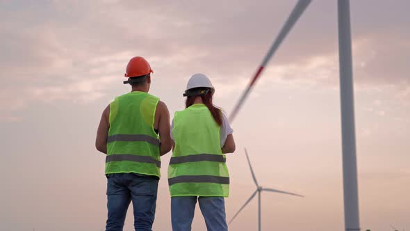 Two Specialist Man and Woman Holding Joystick Controlling Flying Drone Windmills alt