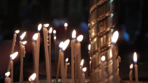 Candles are Burning in the Church Against a Dark Background