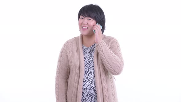Happy Overweight Asian Woman Talking on the Phone Ready for Winter alt