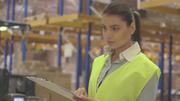 MS Young woman engineer standing and holding clipboard in factory warehouse