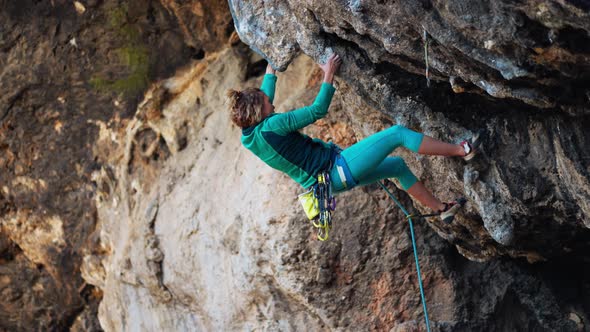 Strong Woman Rock Climber Climbs Hard Tough Rock Route on Very Overhanging Black Cliff in Turkey alt