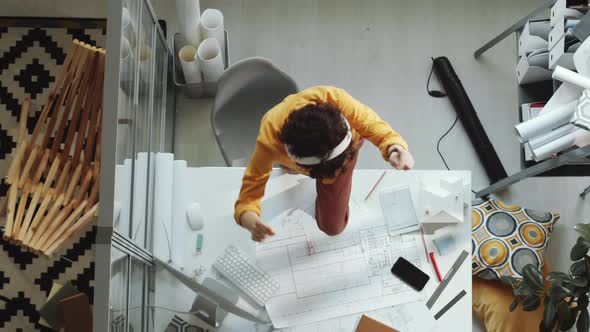 Female Architect in Headphones Dancing on Office Desk alt