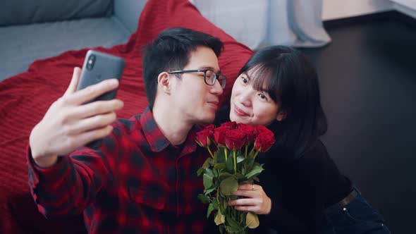 Happy Young Asian Couple Taking Selfie alt