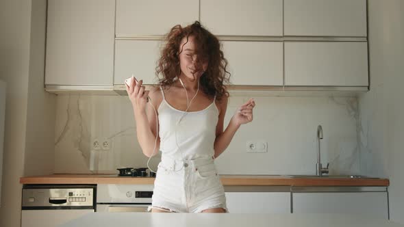 A Young Woman is Listening to Music and Dancing alt